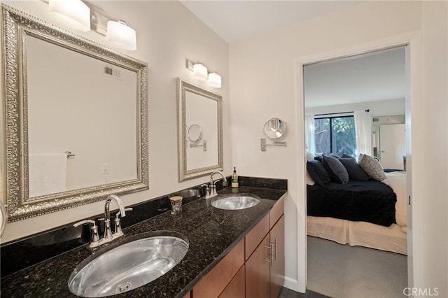 ensuite bathroom with ensuite bathroom, double vanity, a sink, and visible vents