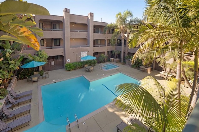 pool with a community hot tub and a patio area