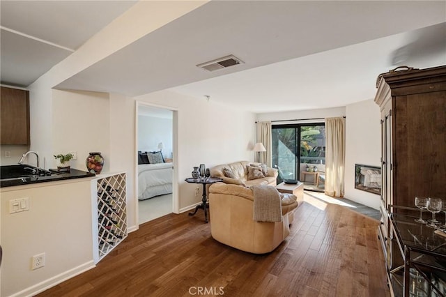 living area featuring dark wood-style floors, visible vents, and baseboards