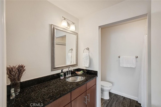 full bath featuring baseboards, vanity, toilet, and wood finished floors