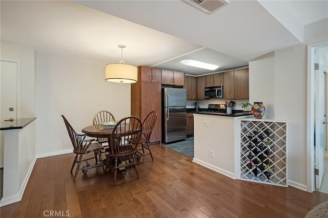 8300 Manitoba St Unit 222, Playa Del Rey, CA 90293 - kitchen with appliances with stainless steel finishes, dark countertops, dark wood-style floors, a peninsula, and baseboards