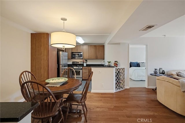 dining room featuring visible vents, baseboards, and wood finished floors