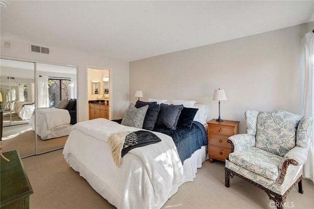 bedroom featuring light carpet, a closet, connected bathroom, and visible vents