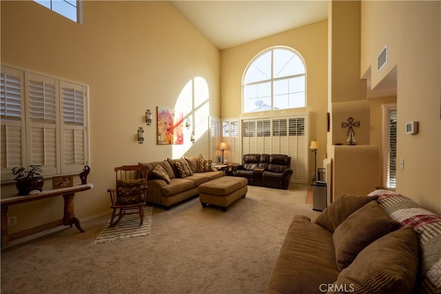 living room with carpet floors, high vaulted ceiling, and plenty of natural light