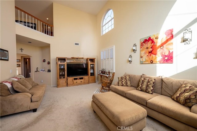 carpeted living room featuring a high ceiling