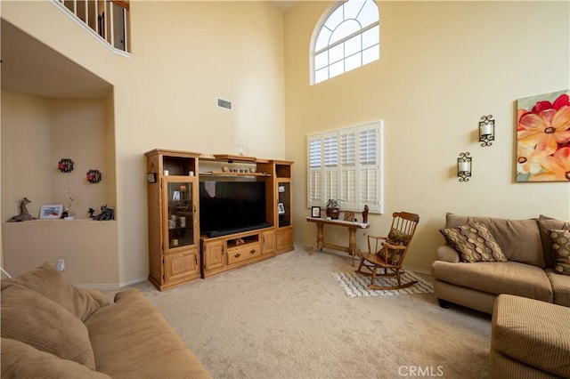 carpeted living room with a high ceiling