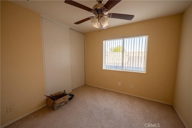 carpeted empty room featuring ceiling fan