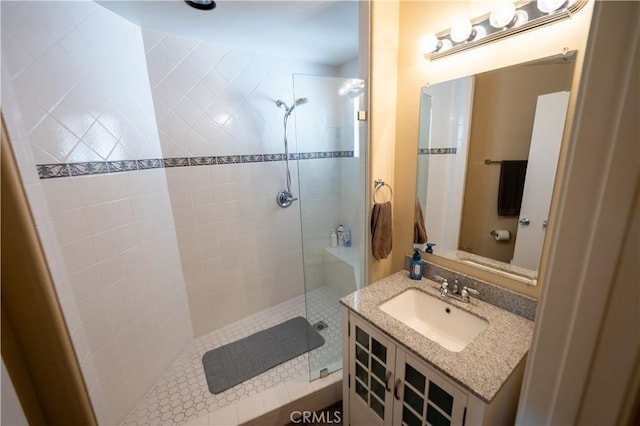 bathroom featuring tiled shower and vanity