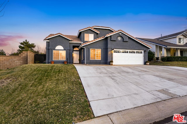 view of front of property featuring a garage and a lawn