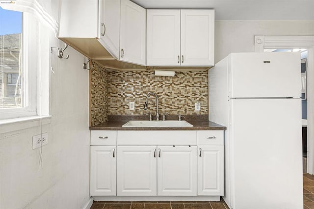 kitchen featuring sink, white cabinets, decorative backsplash, and white fridge