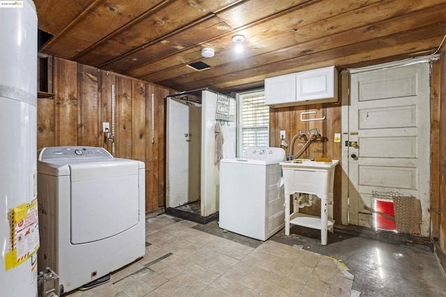 washroom featuring washer and clothes dryer and wooden walls