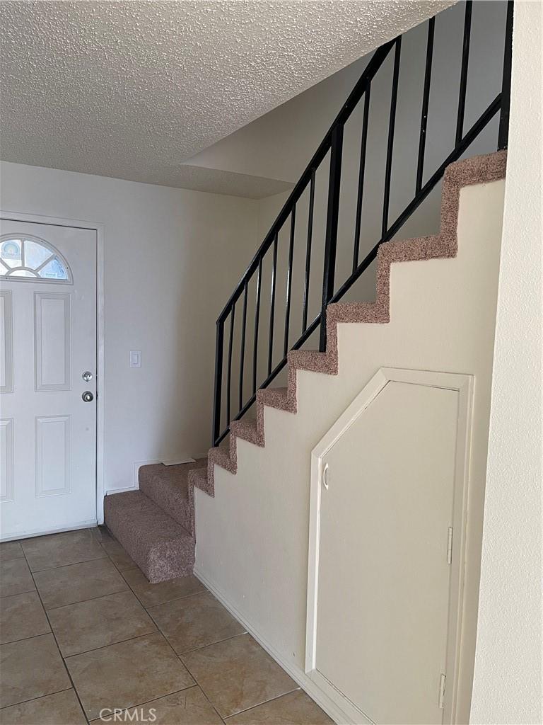 tiled foyer featuring a textured ceiling