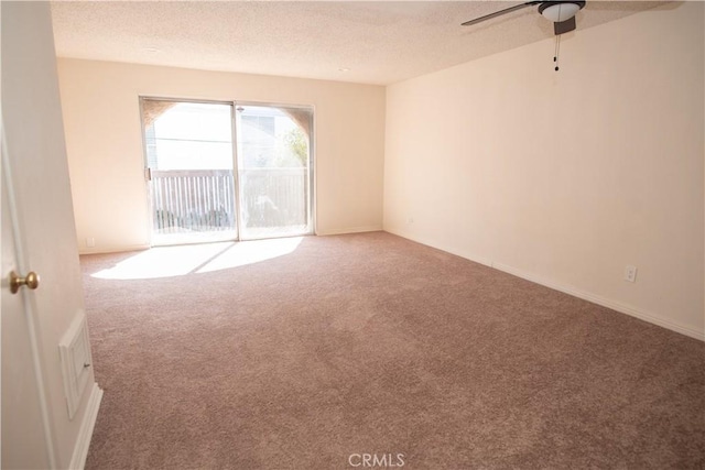 unfurnished room featuring a textured ceiling, ceiling fan, and carpet