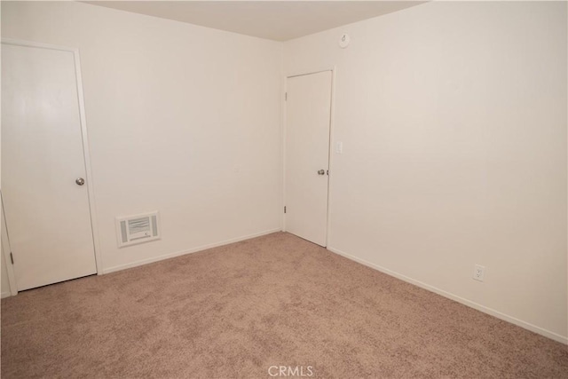 empty room with light carpet, visible vents, and baseboards