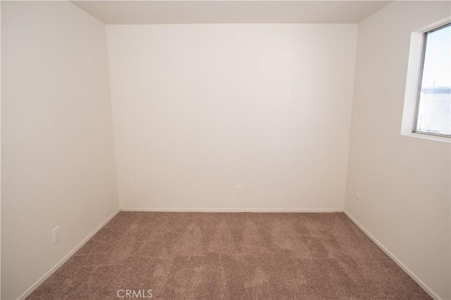 empty room featuring carpet flooring and baseboards