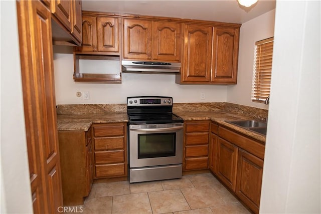 kitchen with brown cabinets, stainless steel electric range oven, under cabinet range hood, and a sink