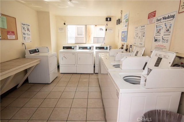 shared laundry area with light tile patterned floors and washing machine and dryer