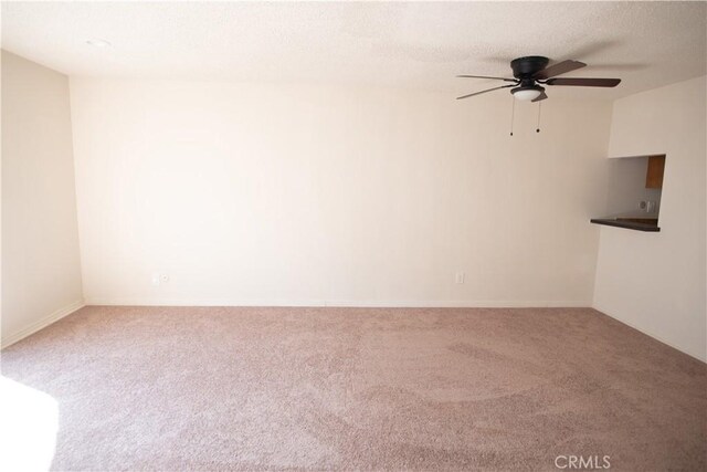 spare room featuring a textured ceiling, carpet flooring, and a ceiling fan