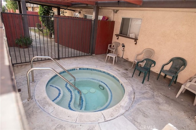 view of pool featuring a community hot tub, a patio, and fence