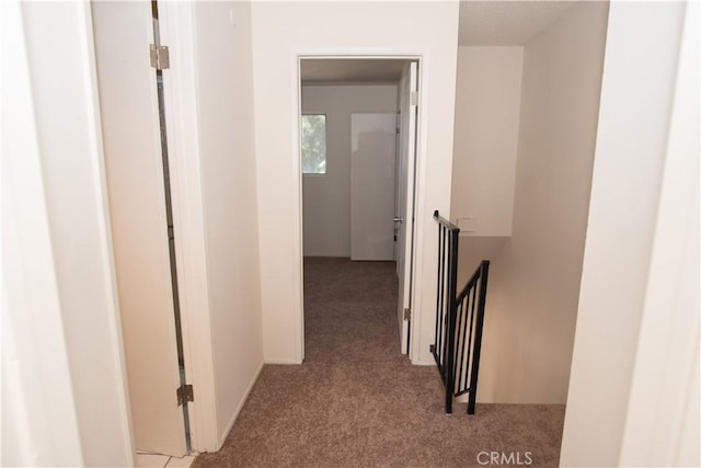 corridor with carpet flooring and an upstairs landing