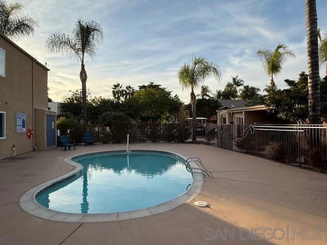 pool at dusk featuring a patio area