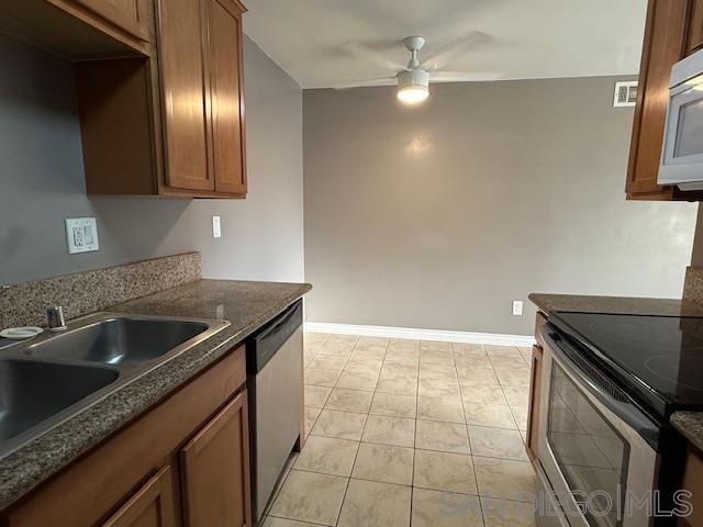 kitchen with sink, stainless steel appliances, ceiling fan, and light tile patterned floors