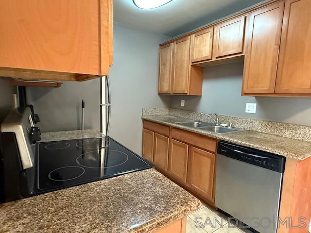 kitchen featuring stove, light tile patterned flooring, stainless steel dishwasher, and sink