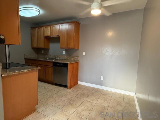 kitchen featuring stainless steel dishwasher, black electric stovetop, light tile patterned floors, and ceiling fan