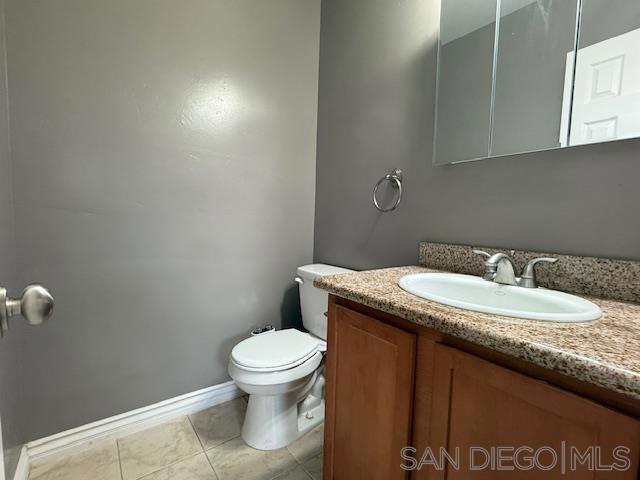 bathroom featuring toilet, tile patterned floors, and vanity