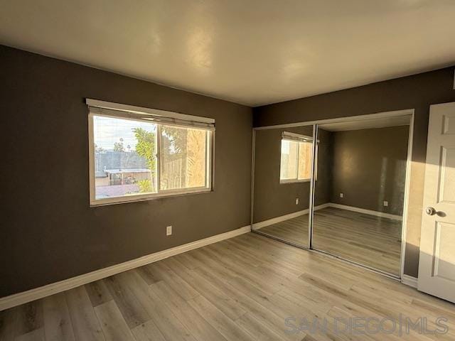 unfurnished bedroom featuring a closet and hardwood / wood-style floors