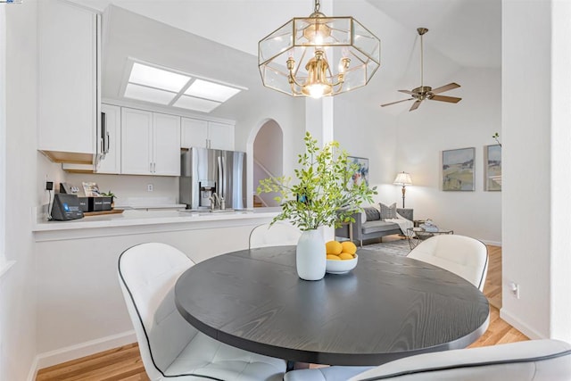 dining space featuring ceiling fan, light hardwood / wood-style flooring, and lofted ceiling