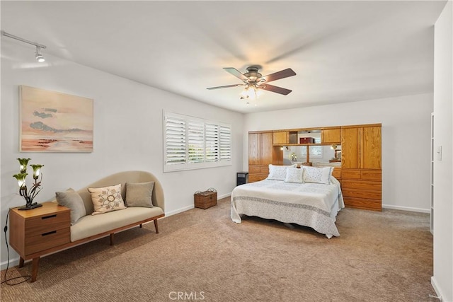 carpeted bedroom featuring rail lighting and ceiling fan