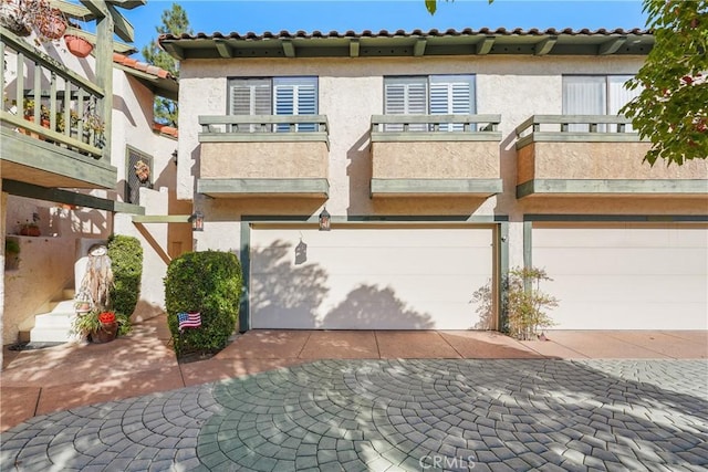 view of front of home featuring a garage and a balcony