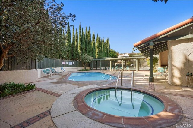 view of swimming pool with a patio area and a hot tub