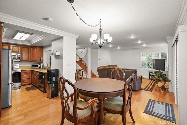 dining room with a notable chandelier, light hardwood / wood-style flooring, crown molding, and sink