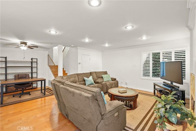 living room featuring crown molding, light wood-type flooring, and ceiling fan