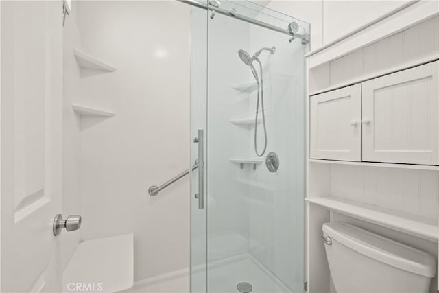 bathroom with toilet and a shower with shower door