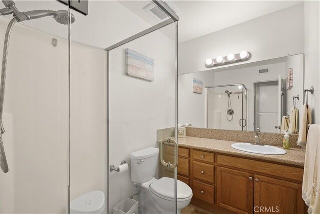 bathroom with a shower with door, toilet, and vanity