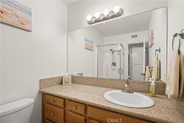 bathroom featuring toilet, walk in shower, and vanity