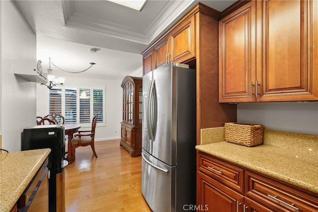 kitchen with crown molding, light hardwood / wood-style flooring, light stone countertops, a chandelier, and stainless steel refrigerator