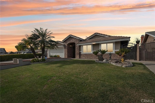 view of front of house featuring a garage and a yard