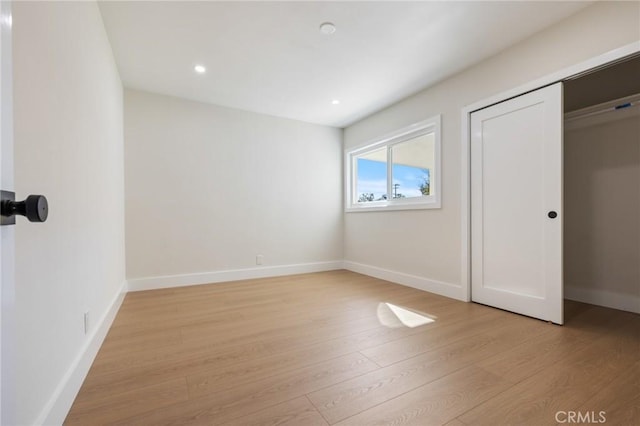 unfurnished bedroom with light hardwood / wood-style floors and a closet