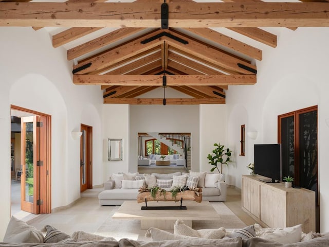 unfurnished living room featuring beamed ceiling and high vaulted ceiling