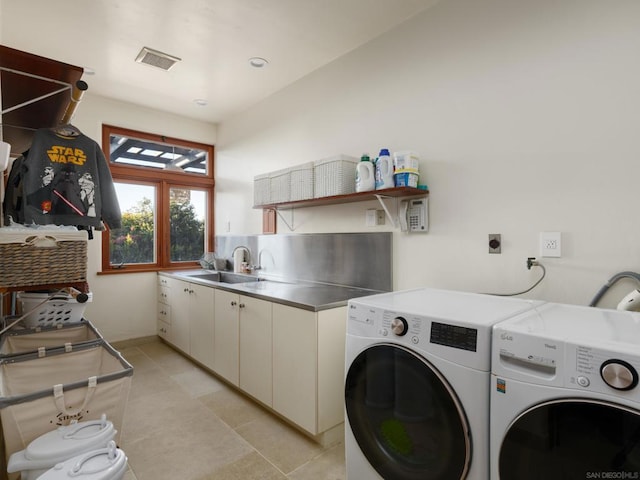 clothes washing area featuring cabinets, washer and clothes dryer, sink, and light tile patterned floors