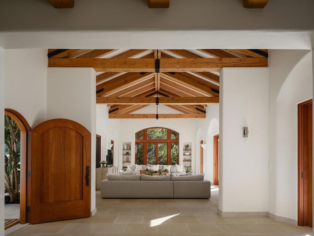 interior space with high vaulted ceiling and beam ceiling