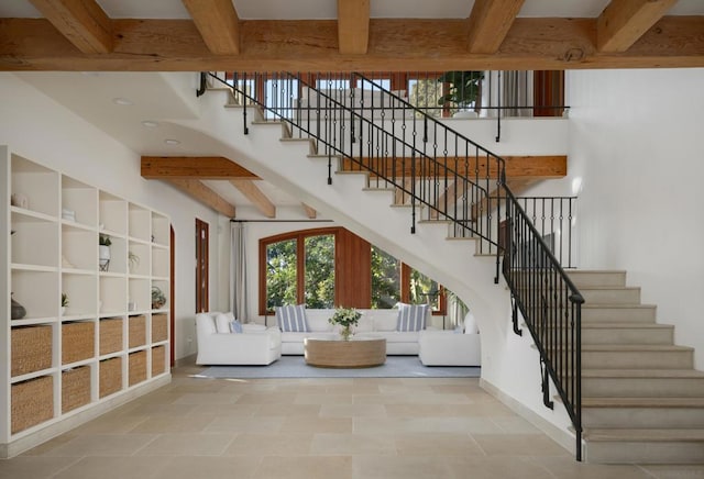 stairs featuring beam ceiling and a towering ceiling