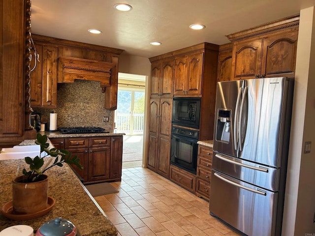 kitchen with decorative backsplash, black appliances, and stone counters