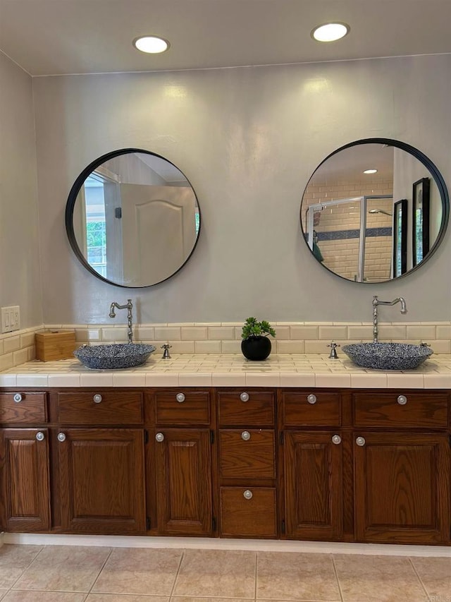 bathroom featuring tile patterned flooring, vanity, and walk in shower