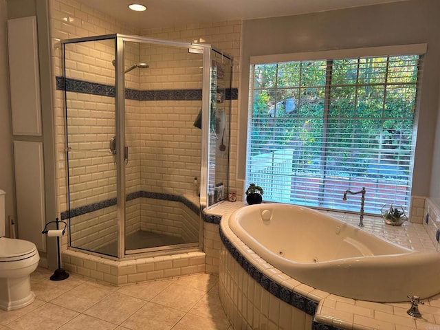 bathroom featuring tile patterned flooring, shower with separate bathtub, and toilet