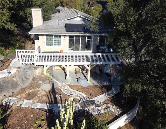 9739 Sage Hill Way, Escondido, CA 92026 - back of house featuring a wooden deck, a chimney, a patio, and roof mounted solar panels